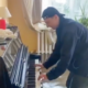 Un hombre toca el piano en una casa inundada en Rusia