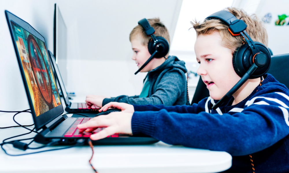 Niños menores jugando videojuegos en línea, escenario donde redes criminales reclutan a adolescentes para actividades violentas en Europa.