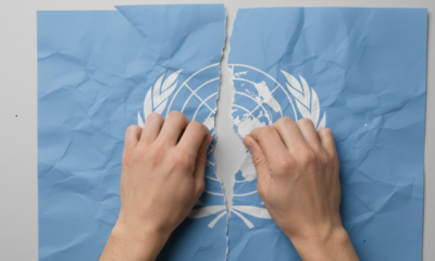 Manos rompen el emblema de la ONU, imagen que representa el retiro de EU de organismos internacionales ordenado por Trump.