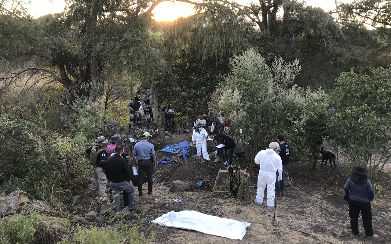 Peritos forenses y policías resguardan zona rural en Villagrán, Guanajuato, donde autoridades localizaron una fosa clandestina.